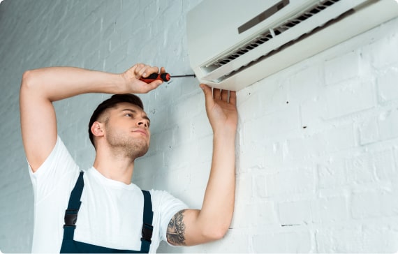HVAC technician servicing air conditioning unit